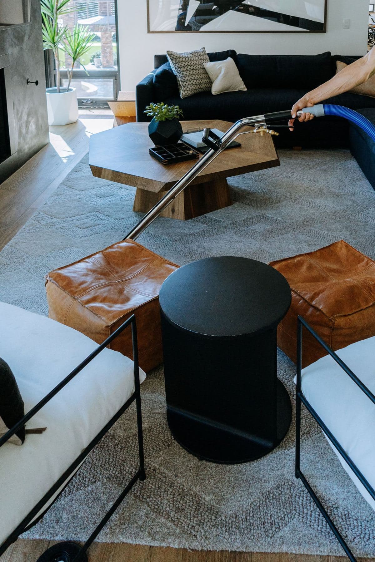 Cleaning a living room rug around leather ottomans