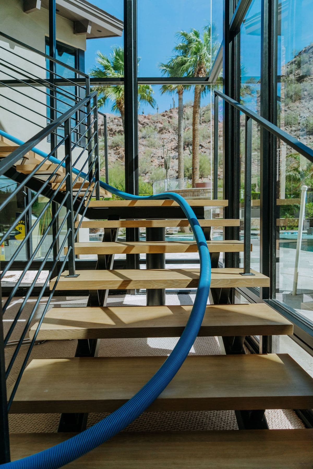 Cleaning hose running up a floating staircase